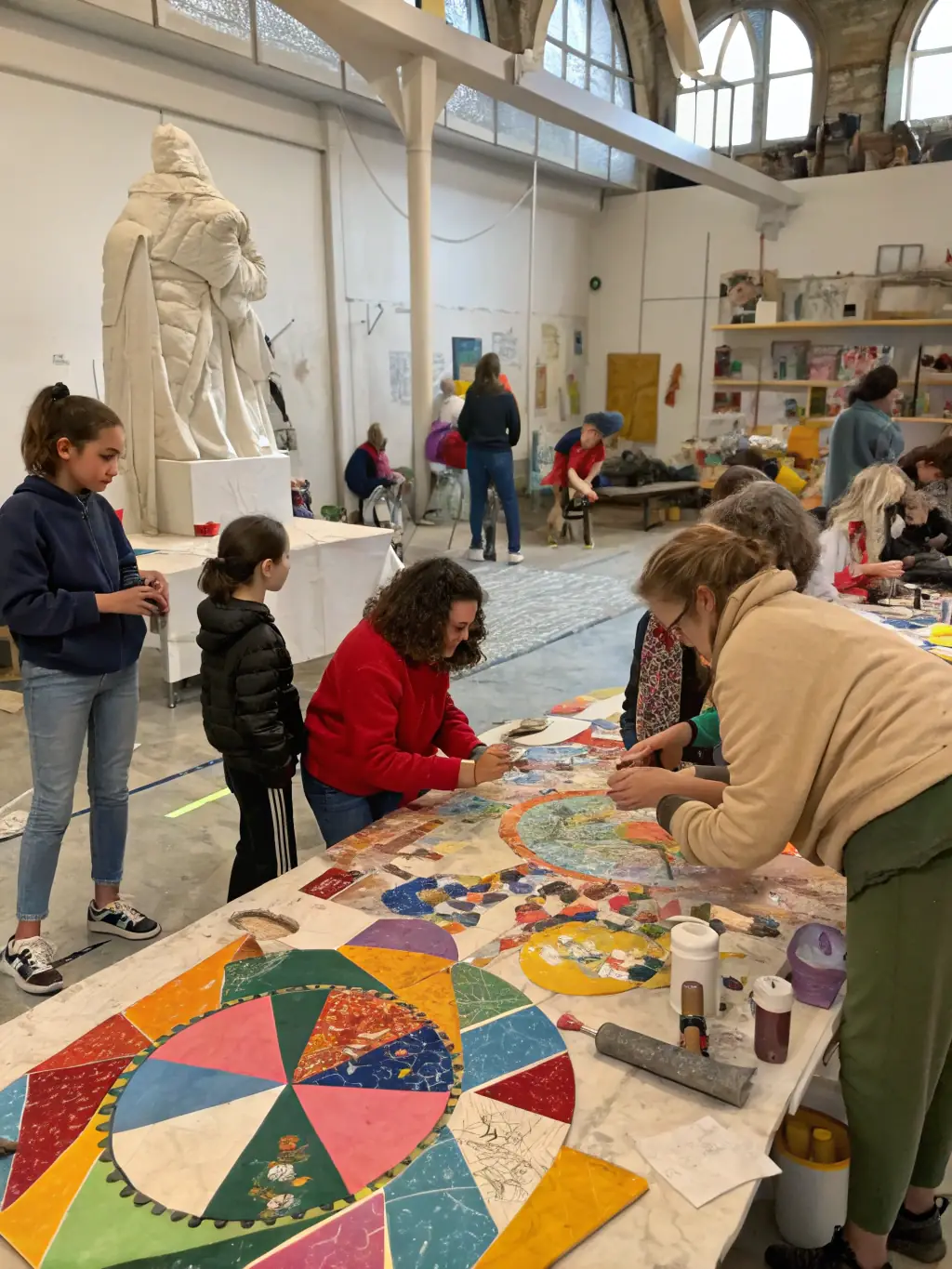 A vibrant photograph capturing a community art workshop organized by L'AVIS D'ARTISTE, showcasing participants of all ages engaged in painting and creative expression.